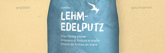 Lehm-Edelputz Lehmocker conluto Lehm-Edelputz im Sack (Farbton Lehmocker) vor Wandausschnitt im selben Farbton