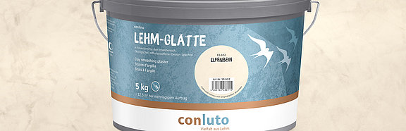 Lehm-Glätte Elfenbein conluto Lehm-Glätte im Eimer (Farbton Elfenbein) vor Wandausschnitt im selben Farbton